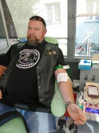 mężczyzna siedzi na fotelu w ambulansie i oddaje krew.