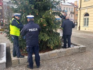 policjanci i Burmistrz dekorują choinkę na placu Kościuszki w Łęczycy.