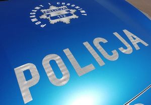 Maska radiowozy w niebieskim kolorze z napisem POLICJA I grafika policyjnej odznaki.