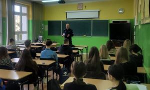 Policjant w klasie rozmawia z uczniami.