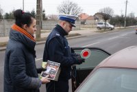 Policjant z kobietą podczas kontroli samochodu.