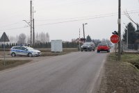Radiowóz na drodze i pojazd służby ochrony kolei.