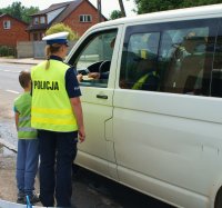 Policjanci z dziećmi kontrolują pojazd.