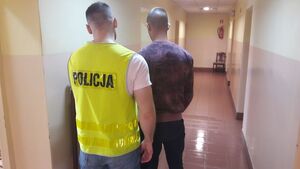 policjant z zatrzymanym wandalem podczas daktyloskopii.