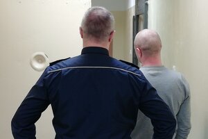 policjant prowadzi zatrzymanego