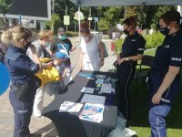 policjanci podczas działań profilaktycznych na stoisku z odwiedzającymi.