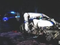 noc, droga rozbite auto osobowe z tyłu radiowóz z włączonymi sygnałami świetlnymi.