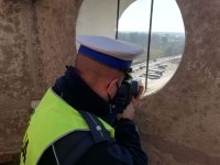 policjant ruchu drogowego z laserem mierzy prędkość na wieży .