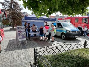 dzieci podczas rozmowy z policjantami na stoisku policyjnym obok radiowozu.