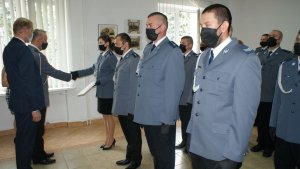 Komendant wraz ze Starostą Łęczyckim wręcza awanse policjantom.