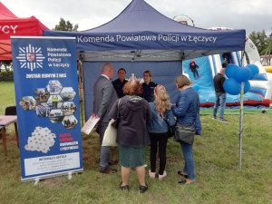 policjanci na stanowisku promocyjnym podczas rozmowy z mieszkańcami.