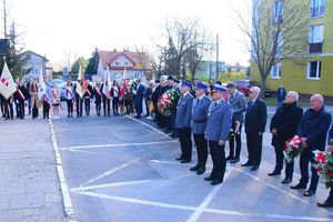 Policjanci , poczty sztandarowe i gości podczas uroczystości stoją przed budynkiem łęczyckiej komendy Policji.