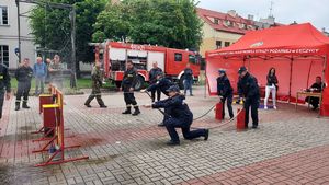 Policjantki podczas konkursu &amp;quot;lania wody&amp;quot; w tle strażacy, wojsko.