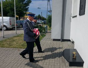 Komendant Powiatowy Policji w Łęczyc wraz ze swoim Zastępca składa kwiaty pod tablica wmurowana w ścianę łęczyckiej komendy policji.