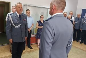 Komendant Powiatowy Policji w Łęczyc podczas przyjmowania meldunku w sali odpraw.
