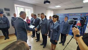 Komendant Powiatowy Policji w Łęczyc podczas  uroczystości w sali odpraw wręcza awanse policjantom.
