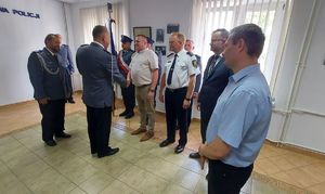 Komendant Powiatowy Policji w Łęczyc podczas  uroczystości w sali odpraw wraz z policjantami i zaproszonymi gośćmi.