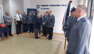 Komendant Powiatowy Policji w Łęczyc podczas  uroczystości w sali odpraw wraz z policjantami i zaproszonymi gośćmi.