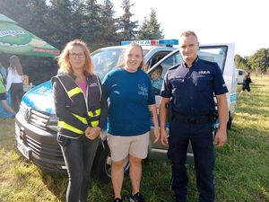 Policjanci z Kobieta przed radiowozem.