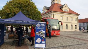 Zaparkowany mobilny punkt poboru krwi obok stoisko policyjne z uczestnikami zbiórki na placu Tadeusza Kościuszki w Łęczycy.