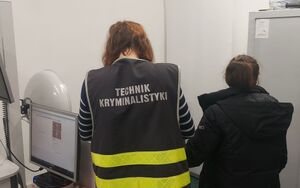 Technik kryminalistyki podczas daktyloskopii zatrzymanej.