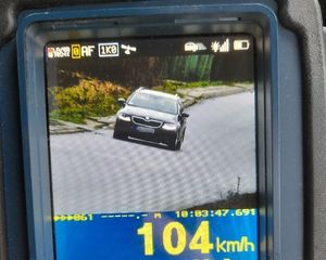 Zdjęcie monitora ręcznego miernika prędkości ze zdjęciem pojazdu, którego zmierzono prędkość.