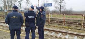 Na zdjęciu na przystanku kolejowym umundurowany Policjant oraz dwóch umundurowanych funkcjonariuszy Straży Ochrony Kolei.