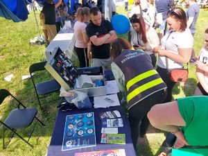 Policjanci na stoisku promocyjnym z odwiedzającymi.