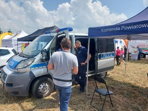 Stoisko promocyjne łęczyckiej policji z odwiedzającymi.