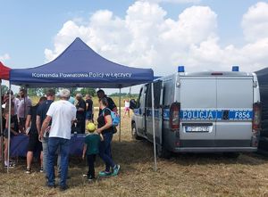 Stoisko promocyjne łęczyckiej policji z odwiedzającymi.