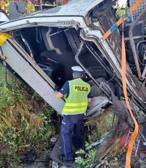 Policjant ruchu drogowego podczas oględzin auta ciężarowego.