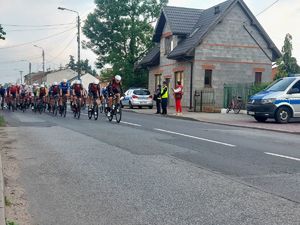 Policjanci, służby porządkowe podczas zabezpieczenia przejazdu wyścigu kolarskiego przez teren ulicy Kutnowskiej w Piątku.