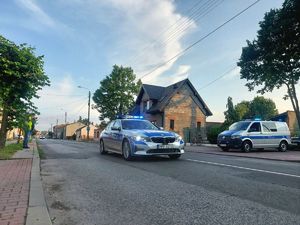 Policjanci, służby porządkowe podczas zabezpieczenia przejazdu wyścigu kolarskiego przez teren ulicy Kutnowskiej w Piątku.