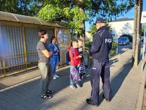 Policjant z dziećmi w drodze do szkoły.