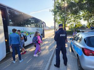 Policjant z dziećmi w drodze do szkoły.