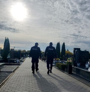 Umundurowani funkcjonariusze w trakcie patrolu pieszego po cmentarzu.