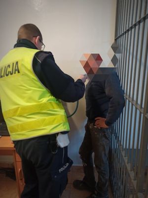 Policjant bada stan trzeźwości kierowcy.