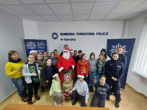 Uczniowie, policjantki z Mikołajem pozują do zdjęcia.
