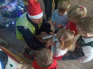 Policjanci podczas rozmowy z przedszkolakami w sali.