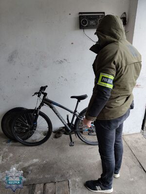 Policjant w pomieszczeniu z odzyskanym rowerem.