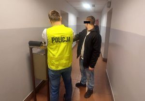 Policjant z zatrzymanym podczas daktyloskopii.