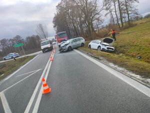 Uszkodzone pojazdy, straż pożarna i policja na miejscu zdarzenia drogowego.