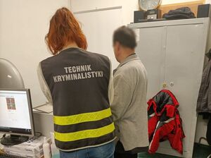Policjantka z zatrzymanym podczas daktyloskopii.