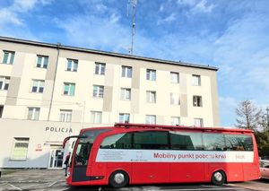 Ambulans przed budynkiem komendy policji wraz z krwiodawcami.