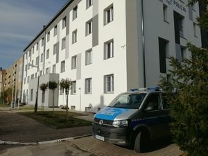 Budynek łęczyckiej policji z zaparkowanym radiowozem.