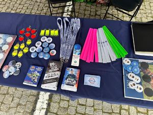 Stoisko promocyjne na pikniku z odwiedzającymi, policjantkami i gadżetami.