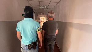 Policjant z zatrzymanym na korytarzu stoją tyłem.