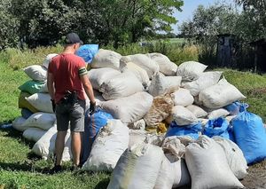 Policjant obok worków z zabezpieczoną kontrabandą.