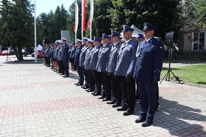 Policjanci w umundurowaniu wyjściowym na placu Tadeusza Kościuszki podczas uroczystości z pocztem sztandarowym i zaproszonymi gośćmi.