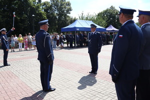 Policjanci w umundurowaniu wyjściowym na placu Tadeusza Kościuszki podczas uroczystości z pocztem sztandarowym i zaproszonymi gośćmi.